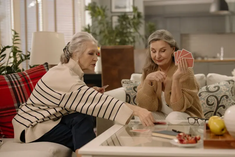 Two neighbors playing gin rummy in a cozy apartment