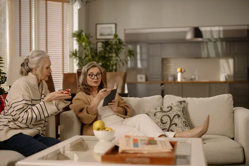 Neighbors talking over fruit and magazines in the sunroom