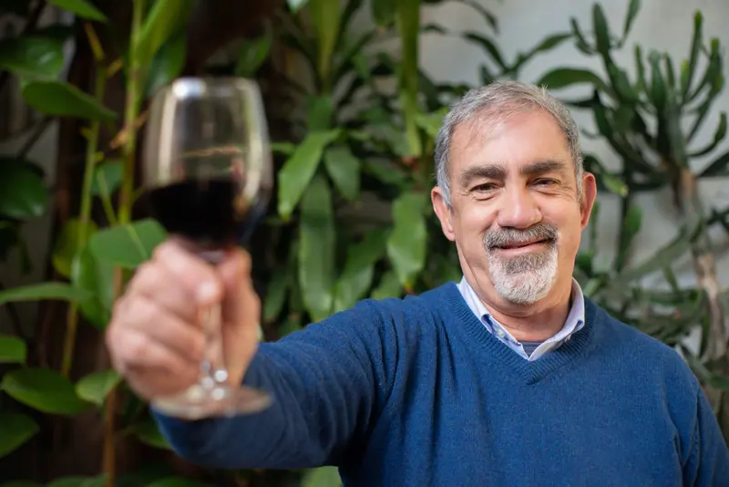 A resident raising his glass to the photographer on the patio