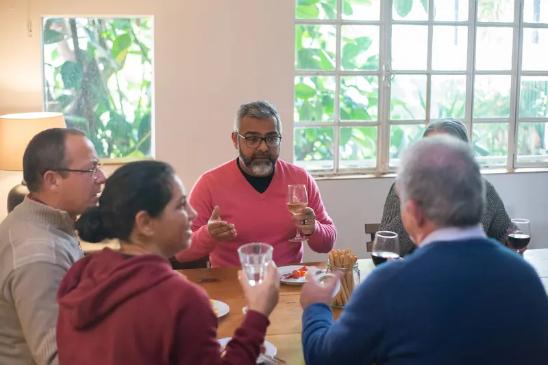 Neighbors laughing over supper by the big windows