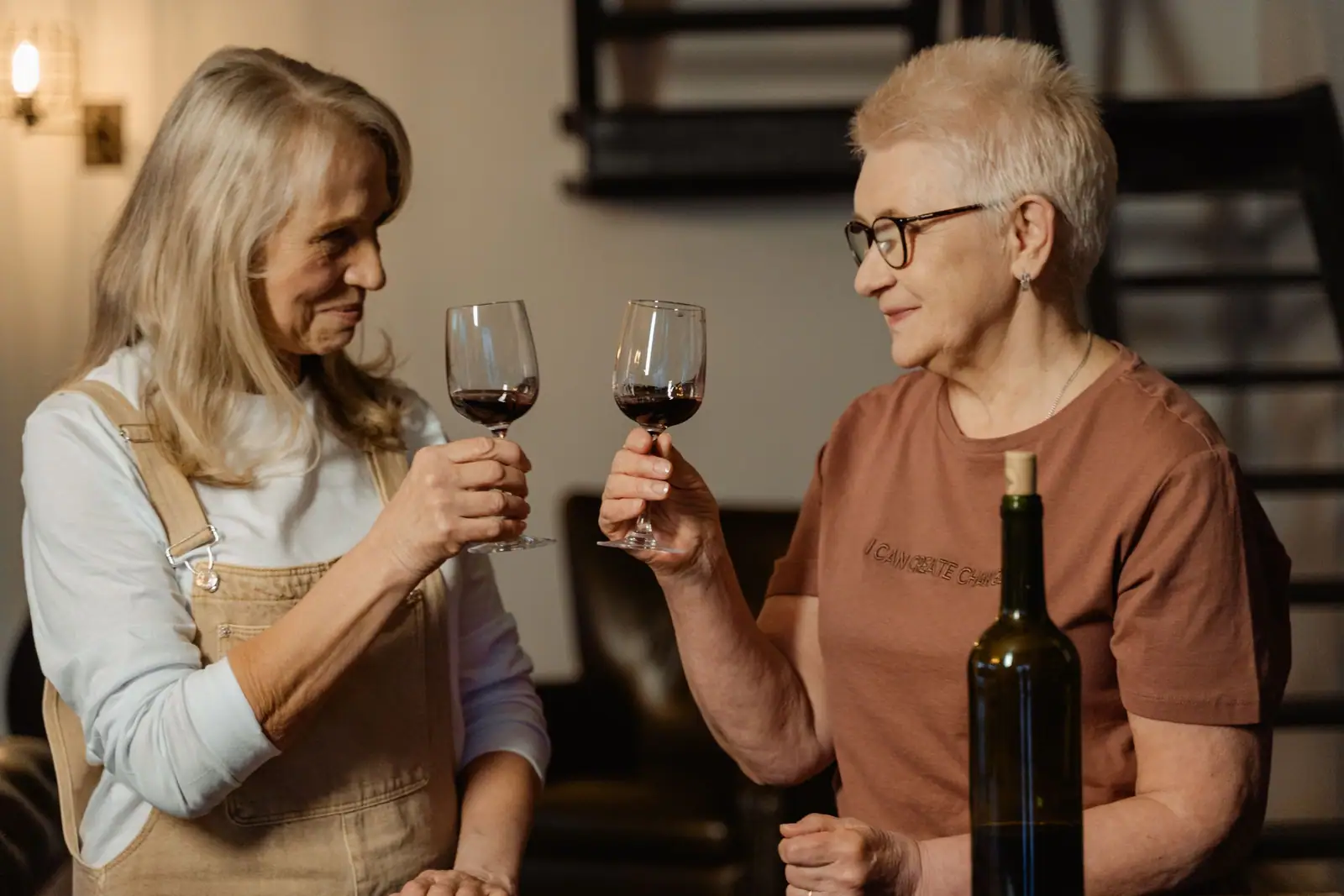 Two residents clinking glasses of red wine at the Thursday tasting in the Terrace House