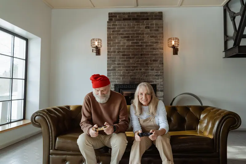 A couple playing video games on their leather sofa