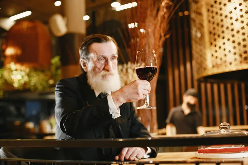 A resident with a glass of red at the bar