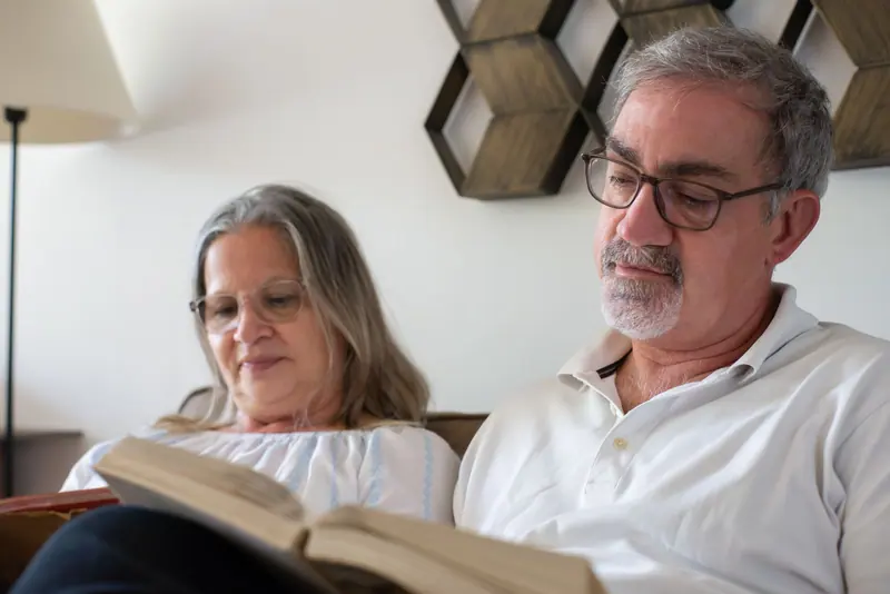 A couple sharing a book in their apartment