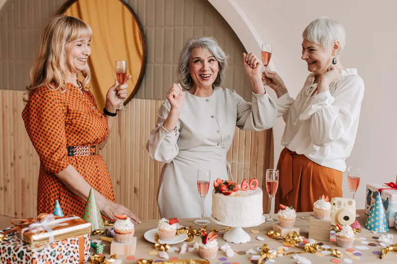 Three friends toasting over a birthday cake