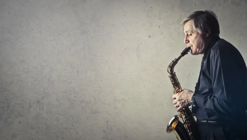 A resident playing alto saxophone in his practice room