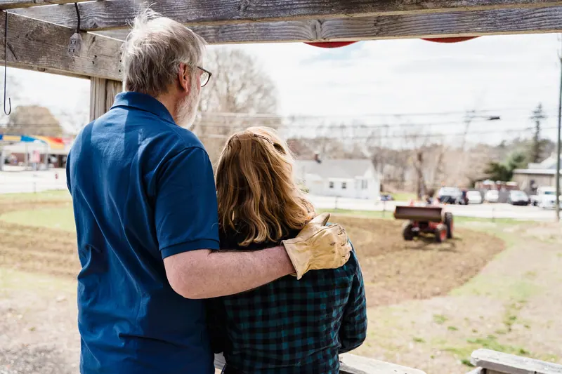 A couple on the farm road, arms around each other
