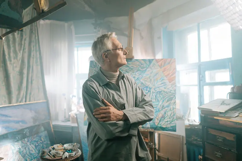 A resident considering his canvas in the painting studio