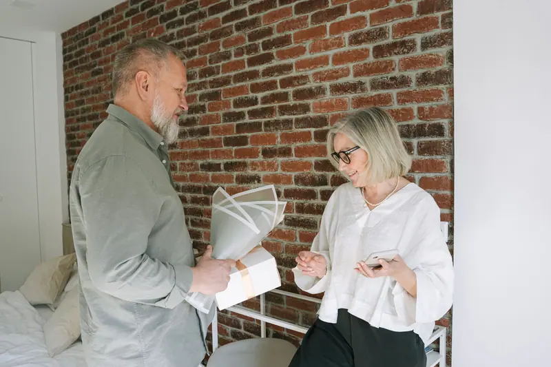 A resident surprising his wife with flowers in their brick-walled loft