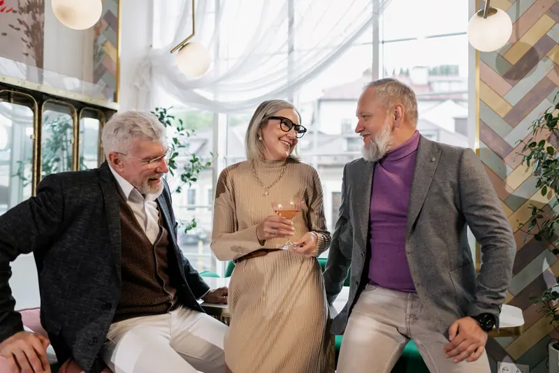 Three neighbors sharing a laugh over drinks in the Pour Room