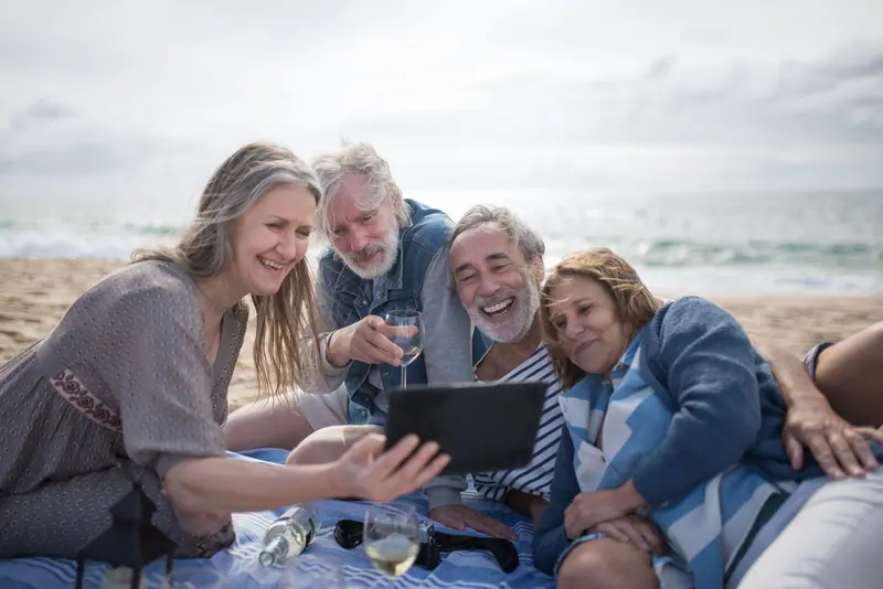 Friends sharing photos from the weekend on a tablet