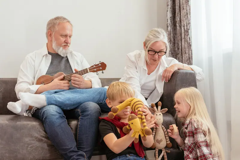 A grandfather playing the ukulele for his grandkids in his apartment