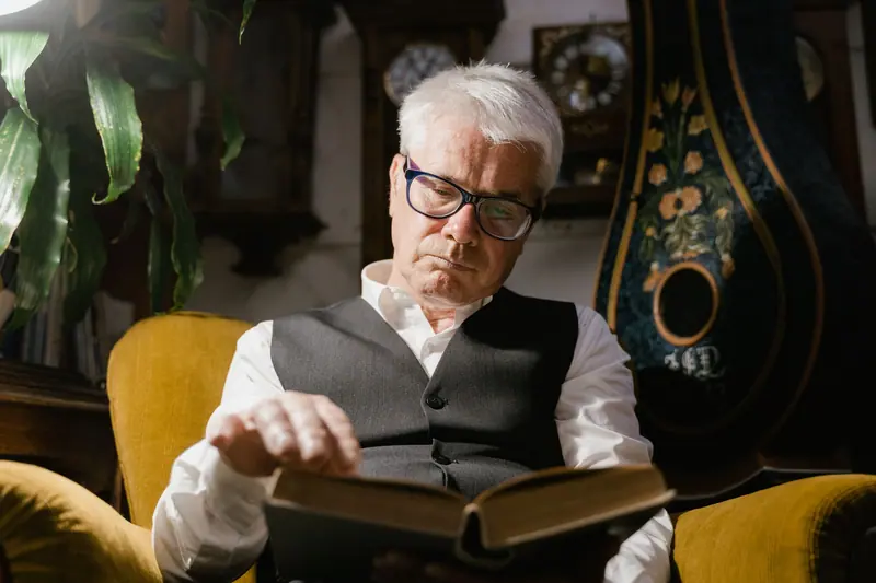 A resident lost in a novel in the yellow armchair