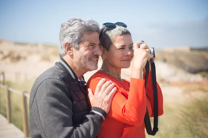 A couple photographing birds at the edge of the refuge