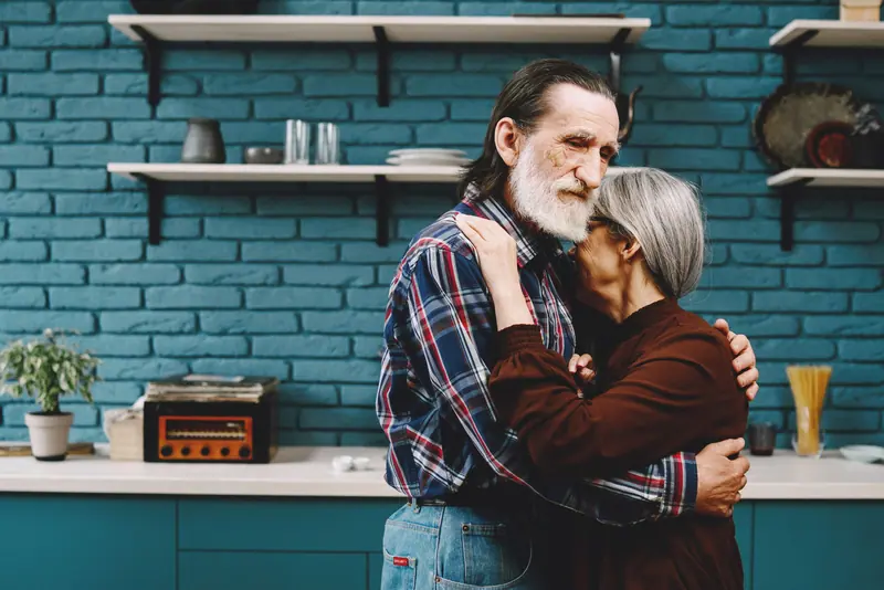A couple hugging in their loft kitchen