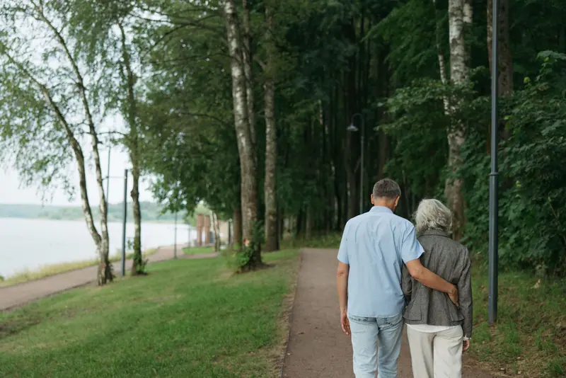 A couple walking arm in arm along the river path