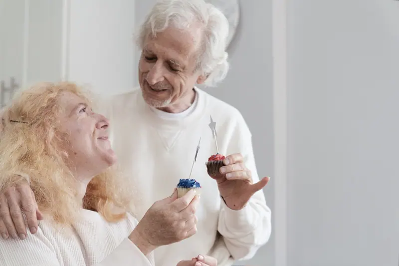 A couple laughing over cupcakes at a birthday party
