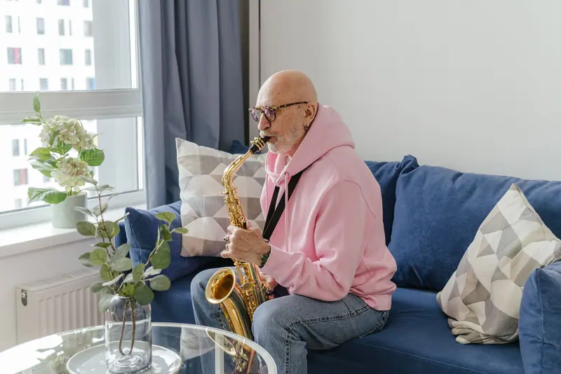 A resident playing saxophone on his living-room sofa
