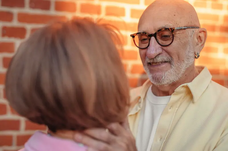 A couple sharing a moment against the brick outside the Pour Room