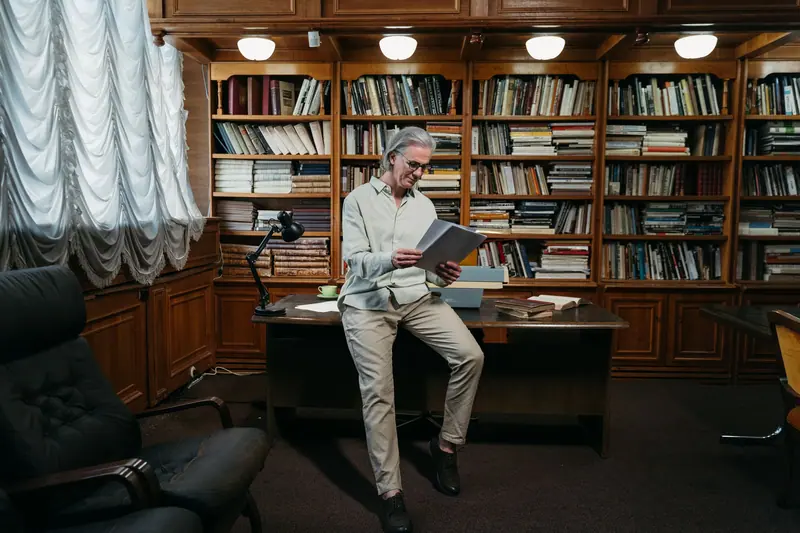 A resident browsing a book beside the library's reading lamps