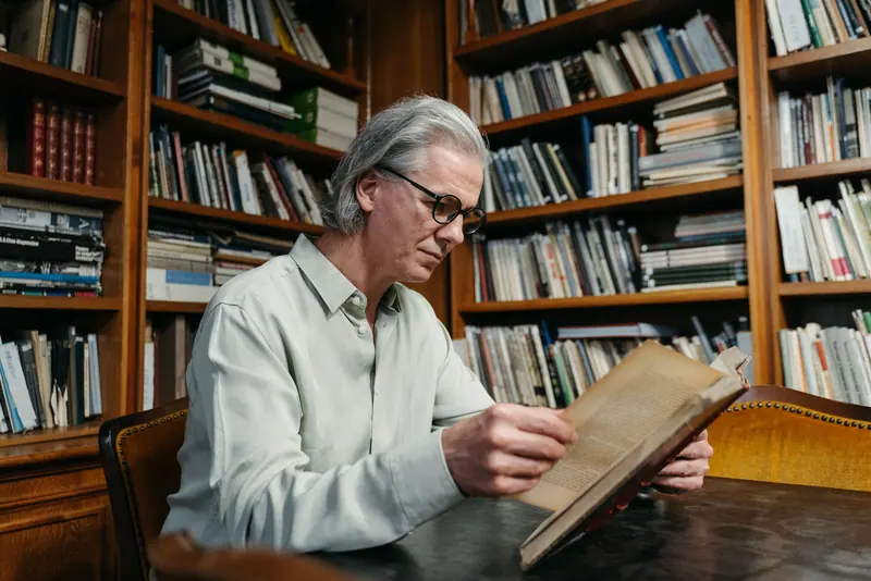 A resident reading in the paneled library off the lobby