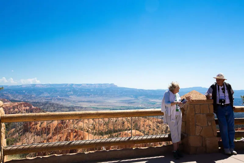 A couple at the overlook, red rock canyon walls stretching out below