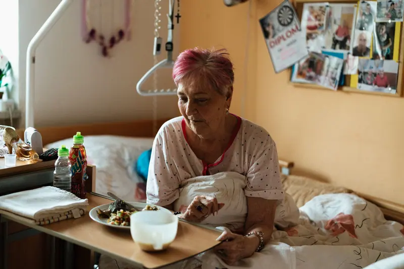A resident laughing over breakfast in bed