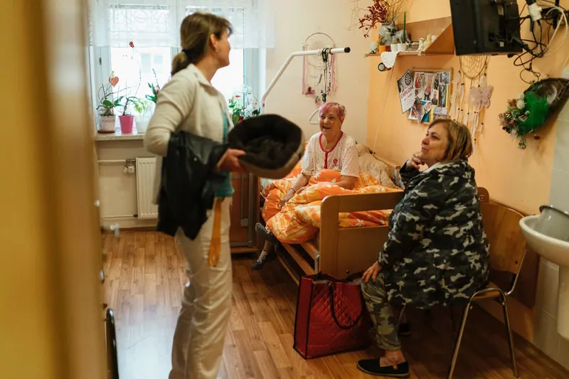 Visitors sitting with a resident in her room