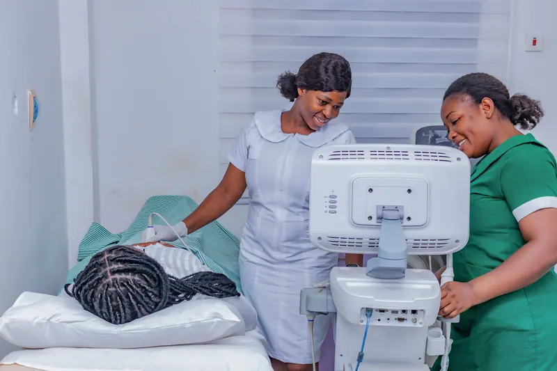 Two nurses laughing together as they prepare a resident's room