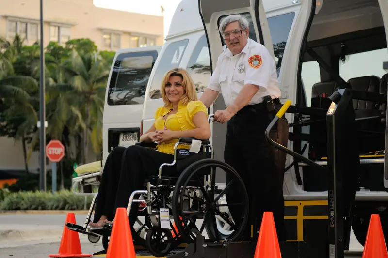 A driver helping a resident onto the wheelchair-lift van for an appointment