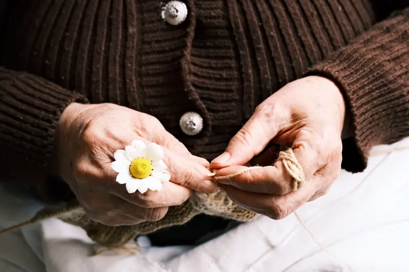 A resident's hands at work on her knitting