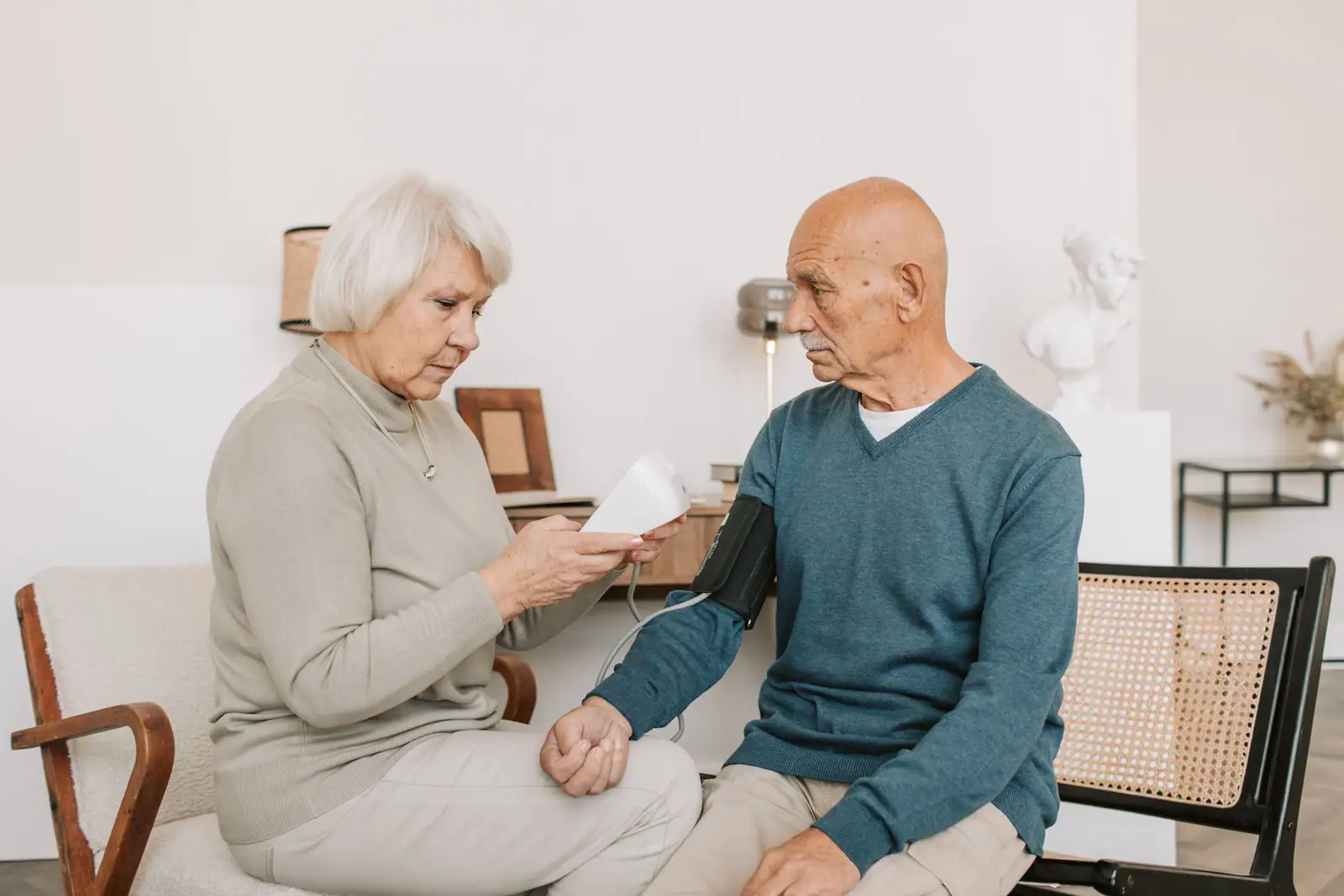 A resident checking her husband's blood pressure in their room