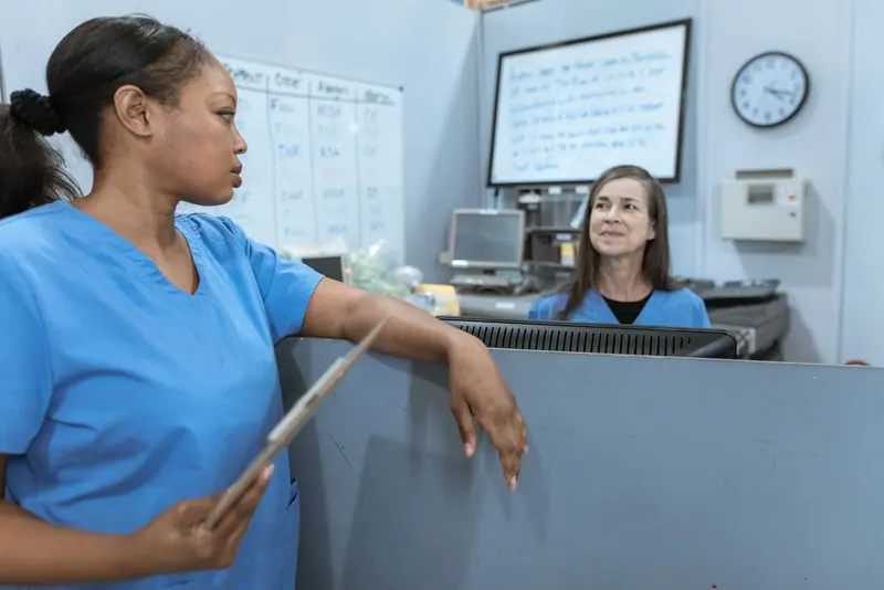 Nurses comparing notes at the station