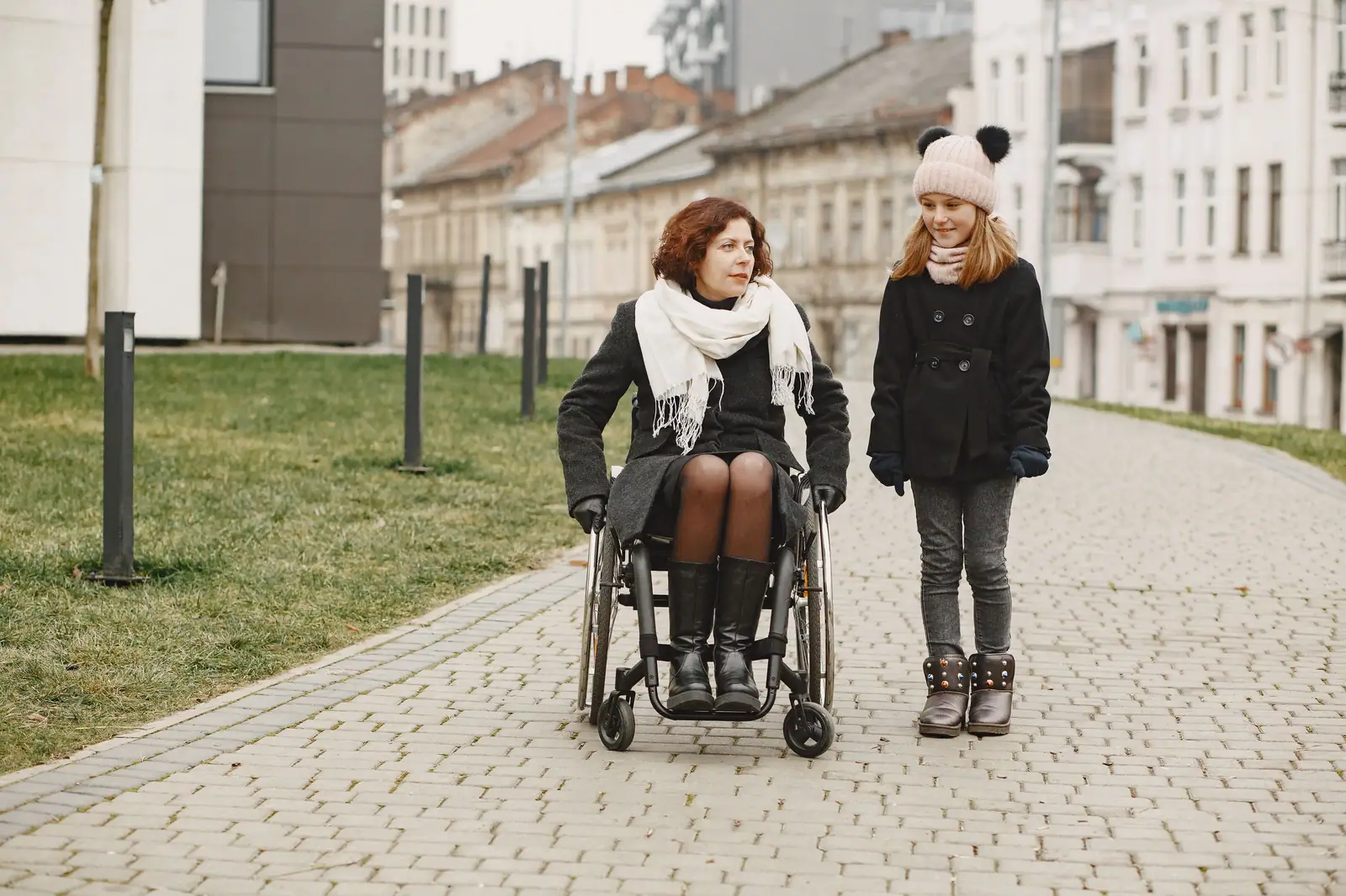 A woman in a wheelchair out for a walk with her granddaughter