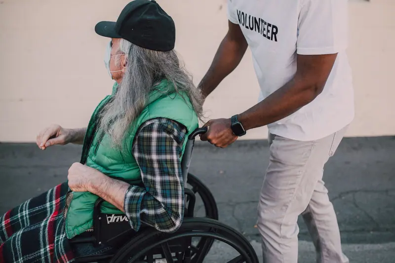 A volunteer pushing a resident's wheelchair on the afternoon walk
