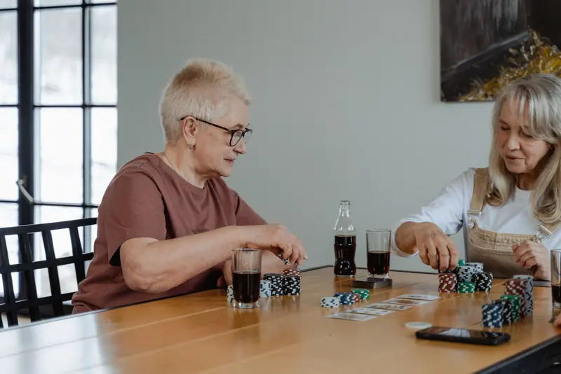 Two residents in the middle of a card game in the sunroom