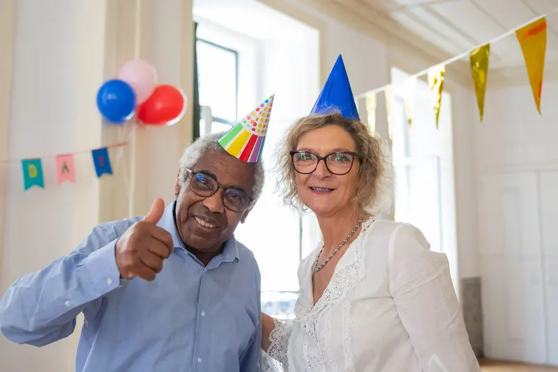 A resident couple in party hats at a birthday celebration