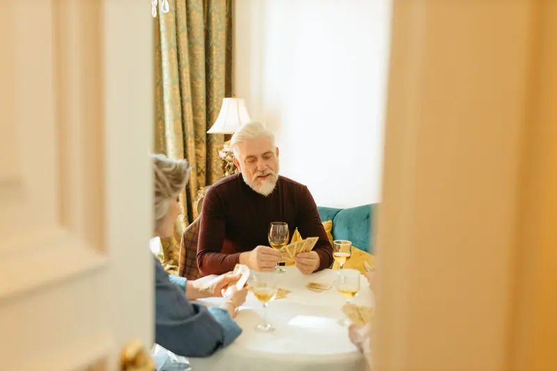 Residents sharing a card game and a laugh in the sitting room