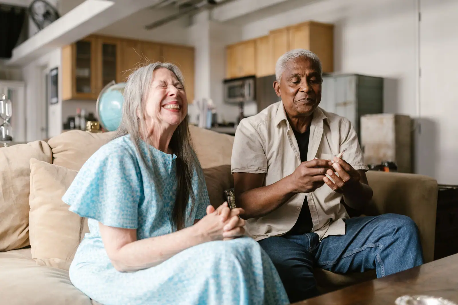 A resident laughing out loud beside a friend on the sofa in the front room