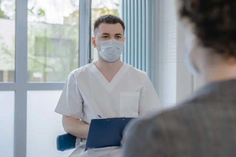 A nurse practitioner taking notes during a visit
