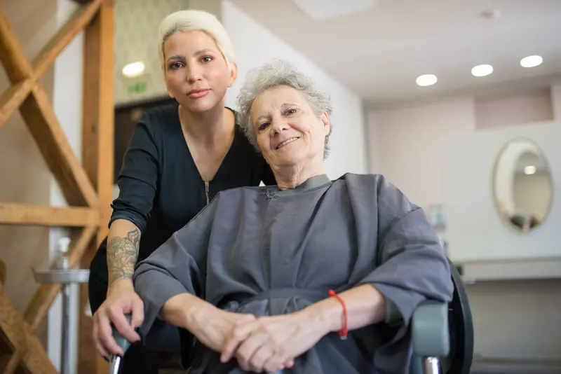 A resident and her stylist after a session in the salon