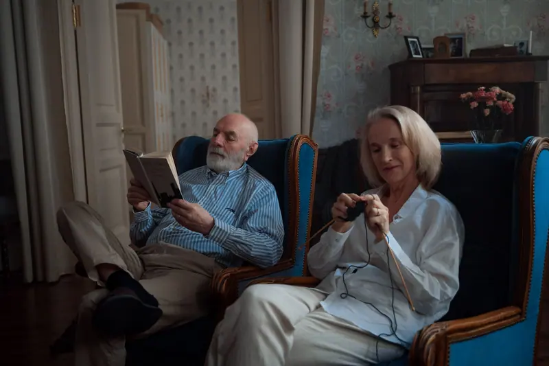 A couple relaxing in blue armchairs in the family lounge